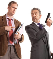 Spy. Image shows from L to R: Tim (Darren Boyd), The Examiner (Robert Lindsay). Image credit: Hat Trick Productions. Spy. Image shows from L to R: Tim (Darren Boyd), The Examiner (Robert Lindsay). Image credit: Hat Trick Productions.