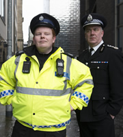 Scot Squad. Image shows from L to R: Officer/Acting Sgt. Ken Beattie (James Allenby-Kirk), Chief Commissioner Cameron Miekelson (Jack Docherty). Copyright: The Comedy Unit. Scot Squad. Image shows from L to R: Officer/Acting Sgt. Ken Beattie (James Allenby-Kirk), Chief Commissioner Cameron Miekelson (Jack Docherty). Copyright: The Comedy Unit.