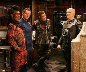 Red Dwarf. Image shows from L to R: Cat (Danny John-Jules), Rimmer (Chris Barrie), Lister (Craig Charles), Kryten (Robert Llewellyn). Copyright: Grant Naylor Productions / BBC. Red Dwarf. Image shows from L to R: Cat (Danny John-Jules), Rimmer (Chris Barrie), Lister (Craig Charles), Kryten (Robert Llewellyn). Copyright: Grant Naylor Productions / BBC.