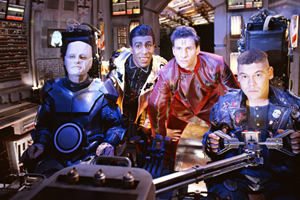 Red Dwarf. Image shows from L to R: Kryten (Robert Llewellyn), Cat (Danny John-Jules), Rimmer (Chris Barrie), Lister (Craig Charles). Copyright: BBC. Red Dwarf. Image shows from L to R: Kryten (Robert Llewellyn), Cat (Danny John-Jules), Rimmer (Chris Barrie), Lister (Craig Charles). Copyright: BBC.