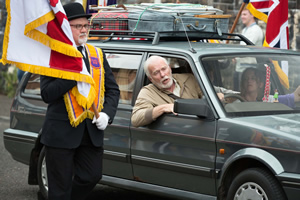 Derry Girls. Image shows from L to R: Unknown, Granda Joe (Ian McElhinney). Copyright: Hat Trick Productions. Derry Girls. Image shows from L to R: Unknown, Granda Joe (Ian McElhinney). Copyright: Hat Trick Productions.