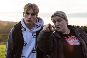 This Country. Image shows from L to R: Lee 'Kurtan' Mucklowe (Charlie Cooper), Kerry Mucklowe (Daisy May Cooper). Copyright: BBC. This Country. Image shows from L to R: Lee 'Kurtan' Mucklowe (Charlie Cooper), Kerry Mucklowe (Daisy May Cooper). Copyright: BBC.