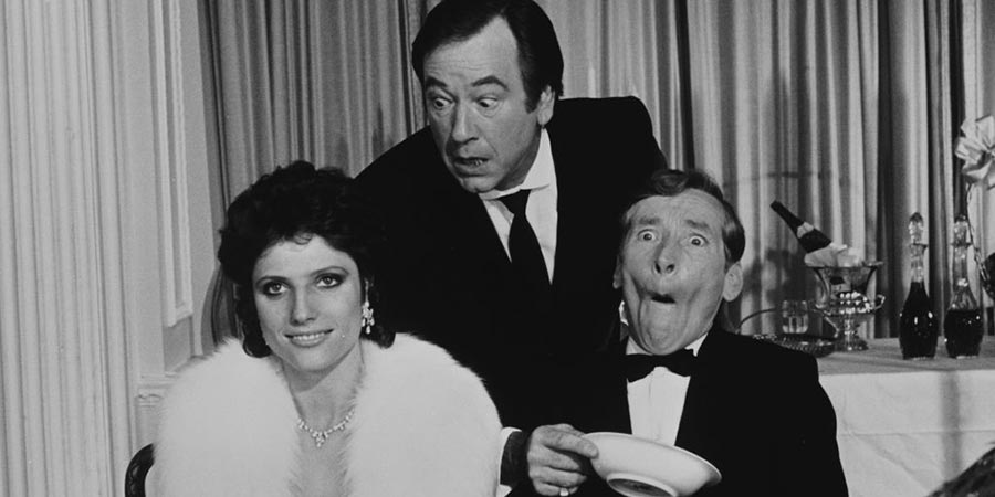Carry On Emmannuelle. Image shows from L to R: Emmannuelle Prevert (Suzanne Danielle), Lyons (Jack Douglas), Ambassador Emile Prevert (Kenneth Williams). Carry On Emmannuelle. Image shows from L to R: Emmannuelle Prevert (Suzanne Danielle), Lyons (Jack Douglas), Ambassador Emile Prevert (Kenneth Williams).