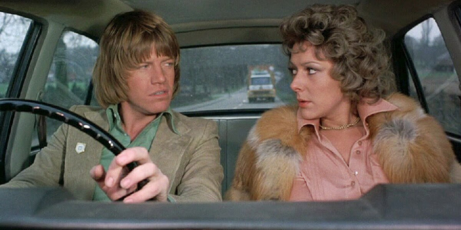 Confessions Of A Driving Instructor. Image shows from L to R: Timothy Lea (Robin Askwith), Mary Truscott (Lynda Bellingham). Copyright: Columbia Pictures. Confessions Of A Driving Instructor. Image shows from L to R: Timothy Lea (Robin Askwith), Mary Truscott (Lynda Bellingham). Copyright: Columbia Pictures.