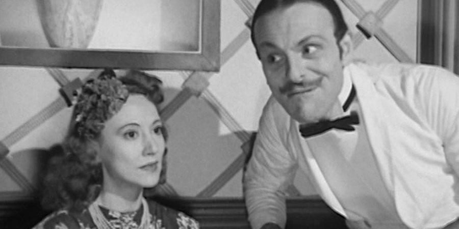 Melody Club. Image shows from L to R: Cora (Lilian Grey), Freddy Forrester (Terry-Thomas). Copyright: Tempean Films. Melody Club. Image shows from L to R: Cora (Lilian Grey), Freddy Forrester (Terry-Thomas). Copyright: Tempean Films.
