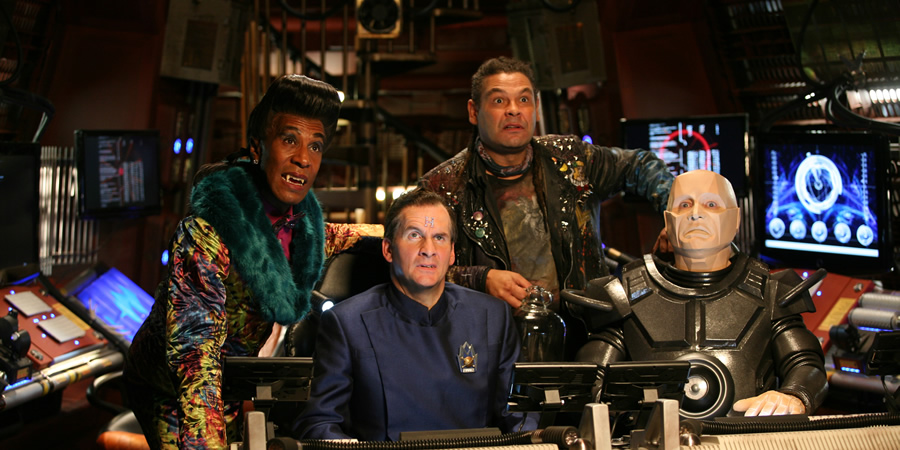 Red Dwarf. Image shows from L to R: Cat (Danny John-Jules), Rimmer (Chris Barrie), Lister (Craig Charles), Kryten (Robert Llewellyn). Copyright: UKTV.