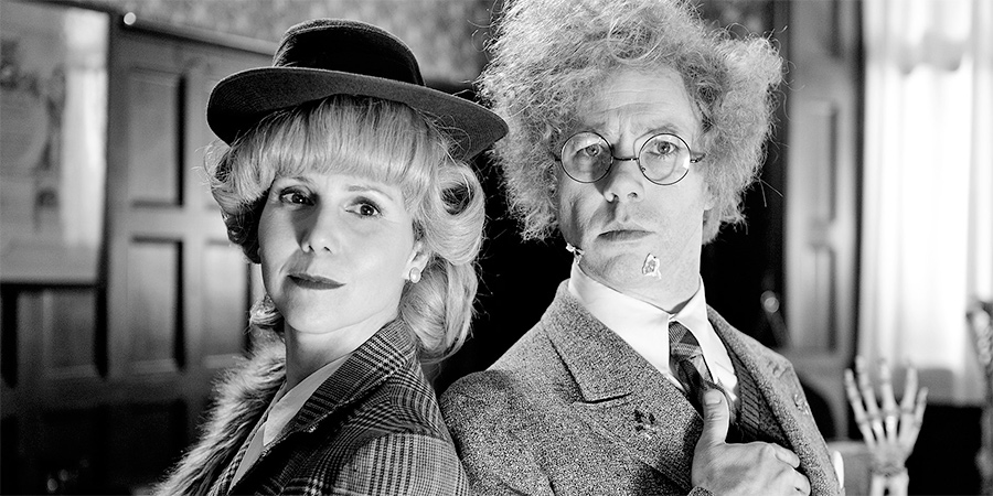 Reece Shearsmith In The Case Of The High Foot. Image shows from L to R: Hilda Stolf (Sally Phillips), Doctor (Reece Shearsmith). Copyright: Pett Productions. Reece Shearsmith In The Case Of The High Foot. Image shows from L to R: Hilda Stolf (Sally Phillips), Doctor (Reece Shearsmith). Copyright: Pett Productions.