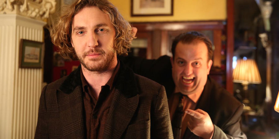 Seann Walsh In Ireland. Image shows from L to R: Robin (Seann Walsh), Hotel Receptionist (Karl Spain). Copyright: Baby Cow Productions / Sky. Seann Walsh In Ireland. Image shows from L to R: Robin (Seann Walsh), Hotel Receptionist (Karl Spain). Copyright: Baby Cow Productions / Sky.