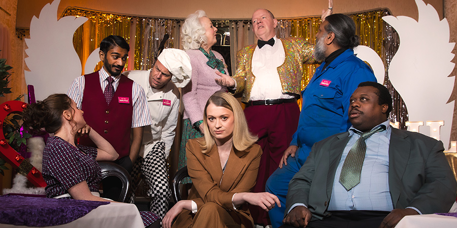 Silky Hotel. Image shows from L to R: Maria Windmill (Léonie Higgins), KP Knuts (Paul G Raymond), Jonathan Sosidge (Bruce Mackinnon), Barbara Blah (Susie Blake), Coral (Sara Cocker), Jim Knightshade (John Henshaw), Sweens (Eugene Rangayah), Ron (Daniel Alexander). Copyright: Charles Leek. Silky Hotel. Image shows from L to R: Maria Windmill (Léonie Higgins), KP Knuts (Paul G Raymond), Jonathan Sosidge (Bruce Mackinnon), Barbara Blah (Susie Blake), Coral (Sara Cocker), Jim Knightshade (John Henshaw), Sweens (Eugene Rangayah), Ron (Daniel Alexander). Copyright: Charles Leek.
