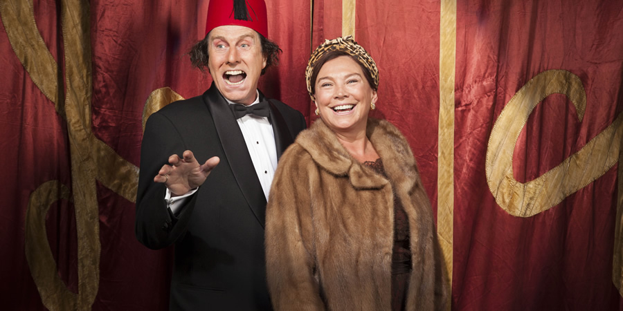 Tommy Cooper: Not Like That, Like This. Image shows from L to R: Tommy Cooper (David Threlfall), Dove Cooper (Amanda Redman). Copyright: Left Bank Pictures. Tommy Cooper: Not Like That, Like This. Image shows from L to R: Tommy Cooper (David Threlfall), Dove Cooper (Amanda Redman). Copyright: Left Bank Pictures.