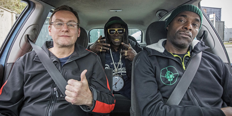Urban Myths: Public Enemy (feat. Kev Wells). Image shows from L to R: Kev Wells (Philip Glenister), Flavor Flav (Abdul Salis), Chuck D (Paterson Joseph). Copyright: Happy Tramp Productions. Urban Myths: Public Enemy (feat. Kev Wells). Image shows from L to R: Kev Wells (Philip Glenister), Flavor Flav (Abdul Salis), Chuck D (Paterson Joseph). Copyright: Happy Tramp Productions.