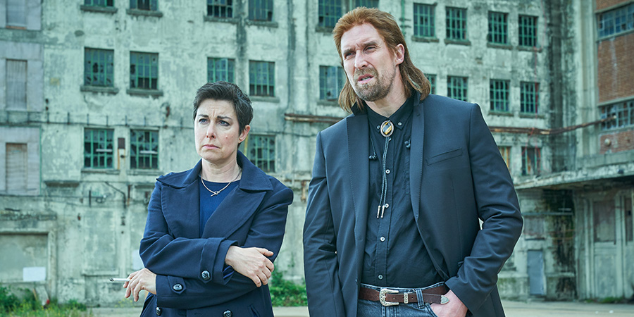 Hitmen. Image shows from L to R: Fran (Sue Perkins), Nikhil (Andrew Brooke). Copyright: Tiger Aspect Productions. Hitmen. Image shows from L to R: Fran (Sue Perkins), Nikhil (Andrew Brooke). Copyright: Tiger Aspect Productions.
