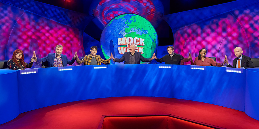 Mock The Week. Image shows from L to R: Angela Barnes, Hugh Dennis, Nigel Ng, Dara O Briain, Rhys James, Athena Kugblenu, Tom Allen. Copyright: Angst Productions. Mock The Week. Image shows from L to R: Angela Barnes, Hugh Dennis, Nigel Ng, Dara O Briain, Rhys James, Athena Kugblenu, Tom Allen. Copyright: Angst Productions.
