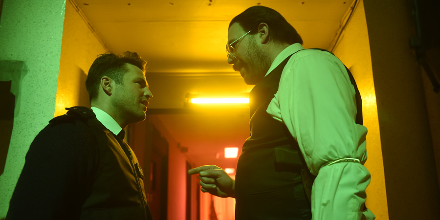 Murder In Successville. Image shows from L to R: Mark Wright, DI Sleet (Tom Davis). Copyright: Tiger Aspect Productions. Murder In Successville. Image shows from L to R: Mark Wright, DI Sleet (Tom Davis). Copyright: Tiger Aspect Productions.