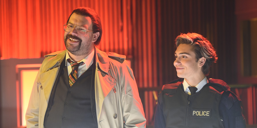 Murder In Successville. Image shows from L to R: DI Sleet (Tom Davis), George Shelley. Copyright: Tiger Aspect Productions. Murder In Successville. Image shows from L to R: DI Sleet (Tom Davis), George Shelley. Copyright: Tiger Aspect Productions.