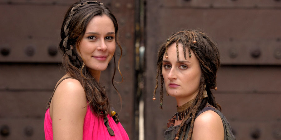 Plebs. Image shows from L to R: Delphine (Bella Dayne), Maya (Laura Elsworthy). Copyright: RISE Films. Plebs. Image shows from L to R: Delphine (Bella Dayne), Maya (Laura Elsworthy). Copyright: RISE Films.