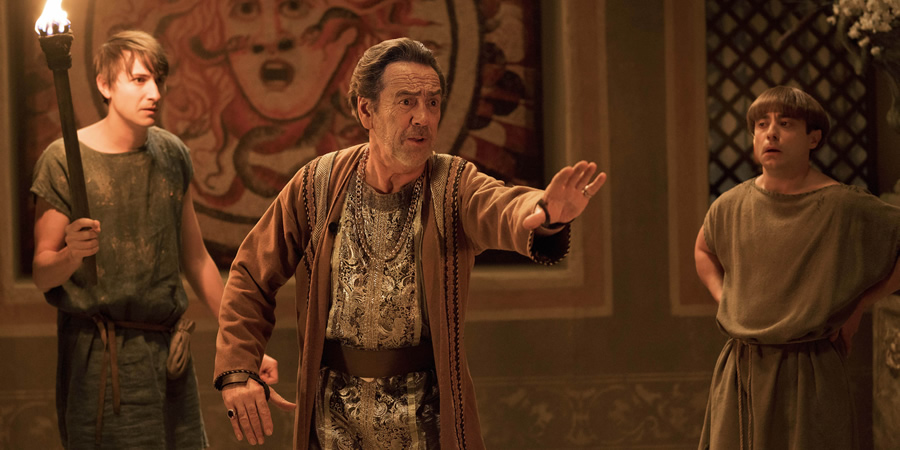 Plebs. Image shows from L to R: Marcus (Tom Rosenthal), Crassus (Robert Lindsay), Grumio (Ryan Sampson). Copyright: RISE Films. Plebs. Image shows from L to R: Marcus (Tom Rosenthal), Crassus (Robert Lindsay), Grumio (Ryan Sampson). Copyright: RISE Films.