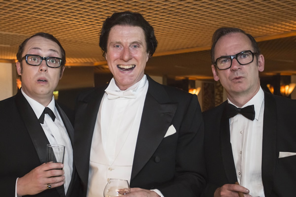 Tommy Cooper: Not Like That, Like This. Image shows from L to R: Eric Morecambe (Bob Golding), Tommy Cooper (David Threlfall), Eric Sykes (Paul Ritter). Copyright: Left Bank Pictures. Tommy Cooper: Not Like That, Like This. Image shows from L to R: Eric Morecambe (Bob Golding), Tommy Cooper (David Threlfall), Eric Sykes (Paul Ritter). Copyright: Left Bank Pictures.