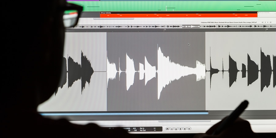 Man Editing Digital Audio on a Computer. Man Editing Digital Audio on a Computer.